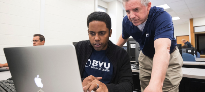 teacher looks at student's computer screen